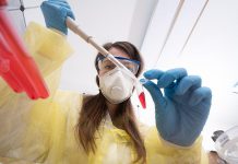 A laboratory worker completes a COVID-19 test