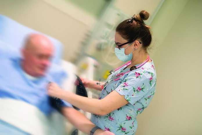 A front-line health care worker at Peterborough Regional Health Centre (PRHC) takes a patient's blood pressure. Thanks to the generosity of local businesses and community leaders, donations to the PRHC Foundation's COVID-19 response fund will now be matched up to $190,000. (Photo: Michael Hurcomb)