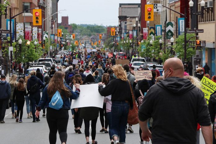 Hundreds of people, wearing masks and walking in small groups due to the COVID-19 pandemic, marched from Millennium Park to Confederation Square in downtown Peterborough on June 2, 2020 during a peaceful protest calling for an end to police violence against black and indigenous people of colour. (Photo courtesy of Sean Bruce)
