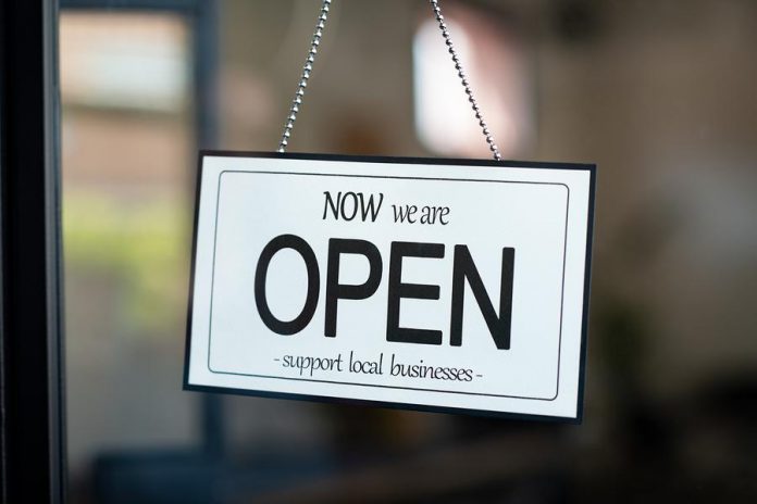 A sign indicating the reopening of a small local business during the COVID-19 pandemic