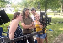 Filmmaker Jamie Oxenham (second from left) with script supervisor Michelle Foster, sound technician Jake Phair, and production assistant Kat Shaw watching actors Steve Kasan and Rick Amsbury (not pictured) during the shooting of "Abra Kadabra" in Lindsay's Victoria Park. (Photo: Sam Tweedle / kawarthaNOW.com)