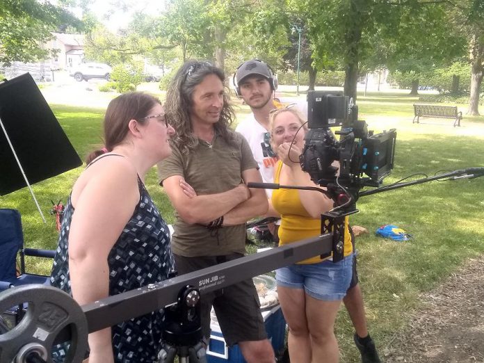 Filmmaker Jamie Oxenham (second from left) with script supervisor Michelle Foster, sound technician Jake Phair, and production assistant Kat Shaw watching actors Steve Kasan and Rick Amsbury (not pictured) during the shooting of "Abra Kadabra" in Lindsay's Victoria Park. (Photo: Sam Tweedle / kawarthaNOW.com)