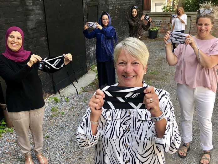 Fleming College president Maureen Adamson (front), New Canadians Centre workplace integration liaison Reem Ali (left), and Madderhouse Textile Studios owner Leslie Menagh (right) with members of the Newcomer Sewing Crew showing off some of the Fleming-branded face masks that will be worn this summer by Fleming students, faculty, and staff. (Photo courtesy of Fleming College)