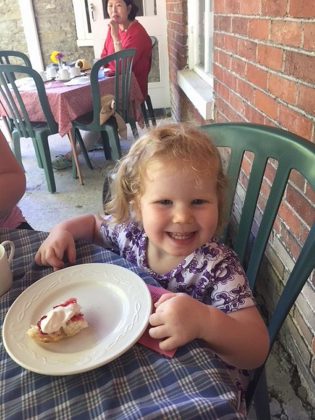 A young visitor enjoys a fresh-baked scone with preserves and whipped cream at a past Scottish Tea at Hutchison House in Peterborough. This year will see some changes in the tea service due to COVID-19. (Photo: Hutchison House / Facebook)