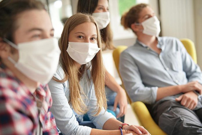 Young people wearing masks during COVID-19 pandemic. (Stock photo)