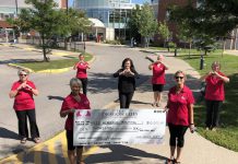 Ross Memorial Hospital Foundation CEO Erin Coons (centre) with members of The Dragon Flies Breast Cancer Survivor Group on August 19, 2020, celebrating the group's $10,000 donation to the foundation for breast cancer health at the Lindsay hospital (from left to right): Maria Bennett, Carol Wilson (holding sign), Kelly Solotarow, Janet Mackey, Jane Graham (holding sign), and Cecile Parker. (Photo courtesy of Ross Memorial Hospital Foundation)
