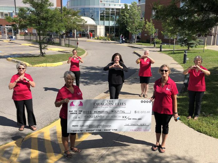 Ross Memorial Hospital Foundation CEO Erin Coons (centre) with members of The Dragon Flies Breast Cancer Survivor Group on August 19, 2020, celebrating the group's $10,000 donation to the foundation for breast cancer health at the Lindsay hospital (from left to right): Maria Bennett, Carol Wilson (holding sign), Kelly Solotarow, Janet Mackey, Jane Graham (holding sign), and Cecile Parker. (Photo courtesy of Ross Memorial Hospital Foundation)