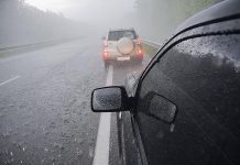 Two cars on a highway in a thunderstorm with hail. (Stock photo)