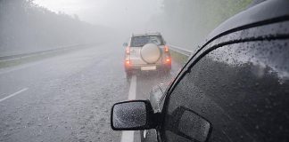 Two cars on a highway in a thunderstorm with hail. (Stock photo)