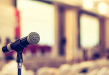 A microphone in an empty meeting space. (Stock photo)