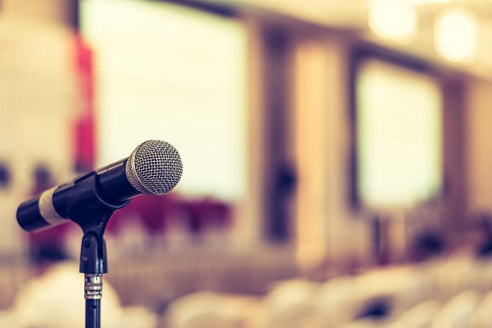 A microphone in an empty meeting space. (Stock photo)