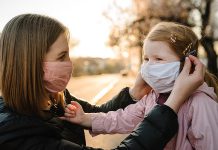 A mother and young girl wearing masks because of the COVID-19 pandemic. (Stock photo)