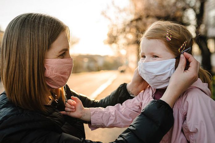 A mother and young girl wearing masks because of the COVID-19 pandemic. (Stock photo)