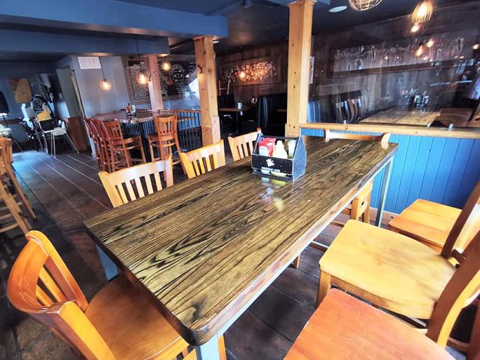 In August, the Exton family completed renovations inside the Canoe & Paddle in Lakefield so they could resume indoor service. In addition to the 16 tables on the extended patio, there are now five tables and eight bar seats inside, with all of them physically distanced or screened with plexiglass to help keep customers and staff safe.  (Photo courtesy of Canoe & Paddle)