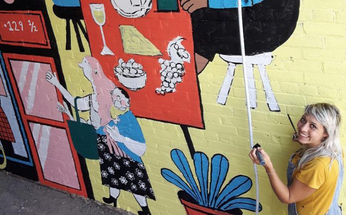 Peterborough illustrator Kathryn Durst at work on her mural in the alleyway of the Commerce Building in downtown Peterborough. The mural, commissioned by the First Friday Peterborough volunteer committee and Commerce Building owner Ashburnham Realty, will be celebrated from 6 to 10 p.m. on Friday, September 4, 2020. (Photo: First Friday Peterborough / Facebook)