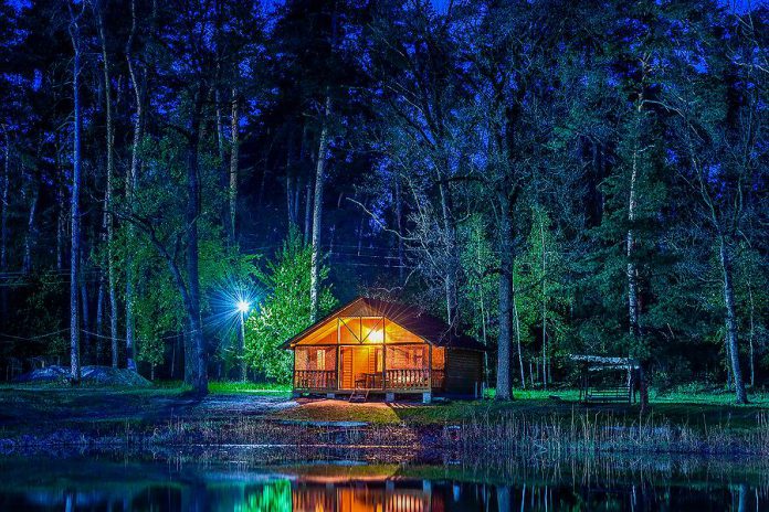 A cottage on a lake at night. (Stock photo)