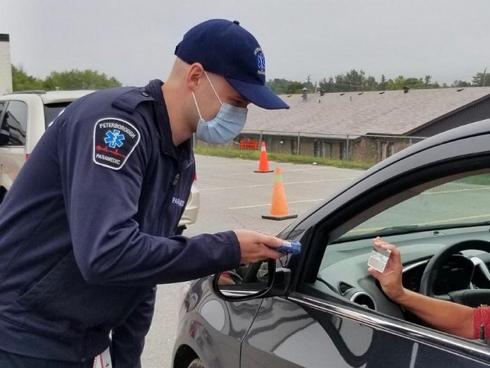 When people arrive for a test at the drive-through COVID-19 testing clinic in Peterborough, staff use a handheld device to scan their health card and driver's licence to digitally capture patient information for the laboratory requisition. This ensures more complete and legible information accompanies the lab requisition for the test. (Photo courtesy of PRHC)