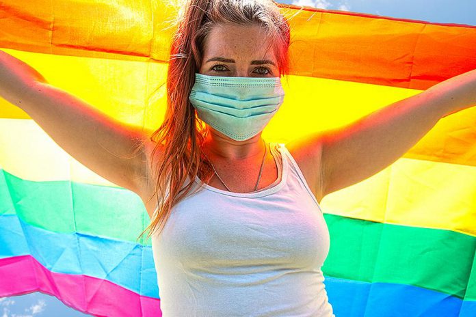 Young woman with rainbow flag. (Stock photo)
