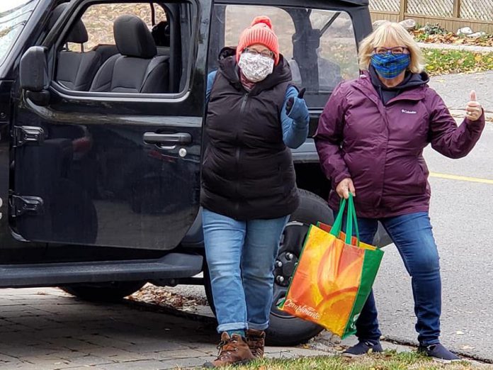 Volunteers Susan Porter Dunkley and Anne Arnold picking up a donation in Peterborough's East City for Kawartha Food Share during the "Spare A Square #2" city-wide porch food drive on October 24, 2020. (Photo: Jeannine Taylor / kawarthaNOW.com)