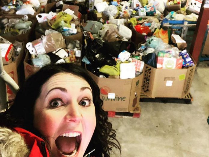 Megan Murphy is organizing "Spare A Square #2", a Peterborough-wide porch food drive on October 24, 2020 to restock the shelves at Kawartha Food Share. Pictured is Megan with some of the over 24,000 pounds of food donations collected during the first Spare A Square porch food drive on March 23, 2020. (Photo: Megan Murphy)