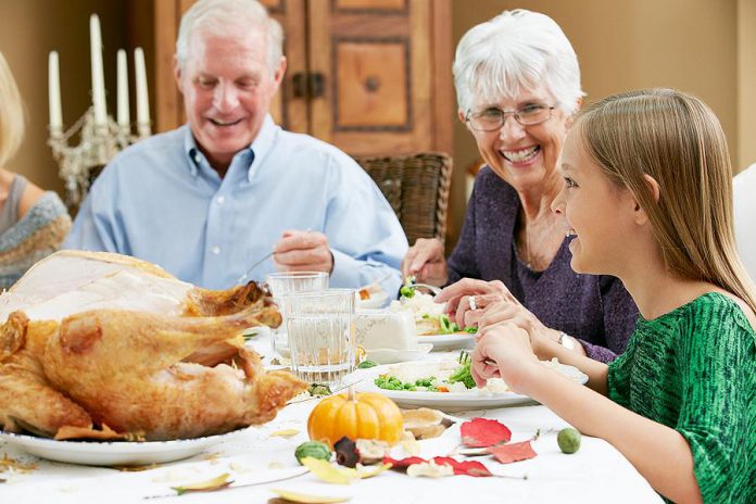 A young girl celebrating Thanksgiving with her grandparents. (Stock photo)