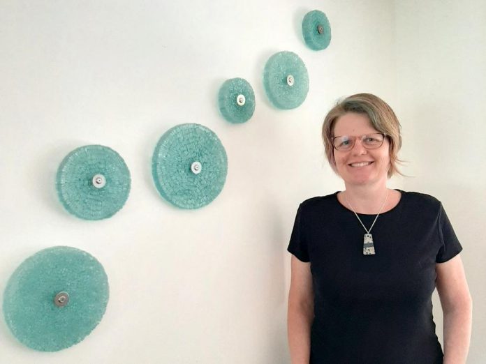 Peterborough-area artist Christy Haldane is renowned for her work in repurposed glass, which she combines with other materials such as stone, concrete, and steel. Now she is creating wearable and functional art using glass and stone, such as the hanging pendant she's wearing in this photo, available online from her website. (Photo: Miller Dodgson)