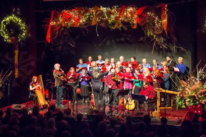 In From The Cold founders Rob Fortin (on guitar), Susan Newman (conducting), John Hoffman (on fiddle), and Curtis Driedger (back row right) performing with the Convivio Chorus at In From The Cold at Market Hall in Peterborough in December 2015. (Photo: Linda McIlwain / kawarthaNOW.com)