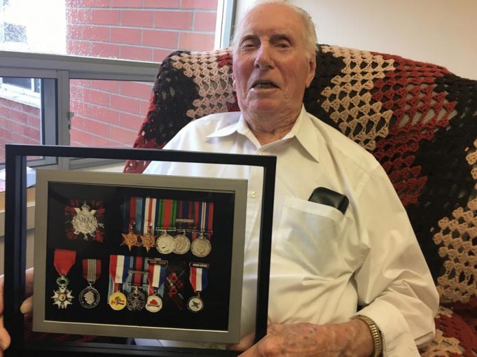 A 98-year-old Joe Sullivan at Fairhaven Long-Term Care Home in Peterborough in 2018, displaying a montage of medals related to his war service. In 2015, Joseph Sullivan was awarded the French National Order of the Legion of Honour (bottom left) in recognition of his war service. (Photo: Paul Rellinger / kawarthaNOW.com)