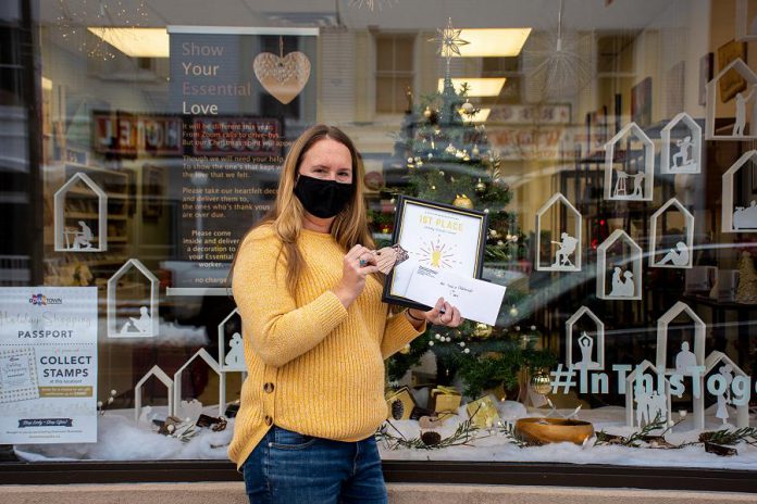 Jenni Johnston, executive director of the Art School of Peterborough at 174A Charlotte Street in downtown Peterborough, with the first place prize in the Peterborough Downtown Business Improvement Area (DBIA)'s annual holiday window contest. (Photo courtesy of Peterborough DBIA)