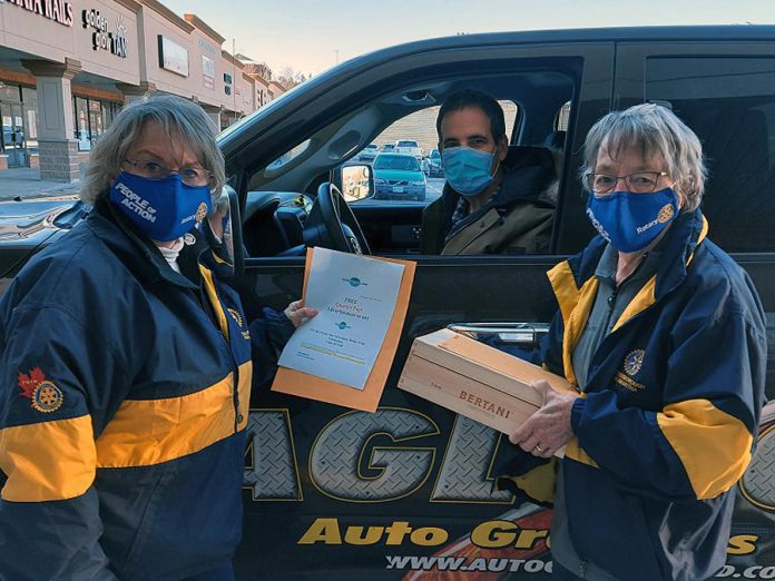 Rotarians Lynne Chant and Dawn Straka provide items to a successful bidder in the pick-up area after the Rotary Club of Peterborough Kawartha's annual Christmas auction, which raised $18,622 for YES Shelter for Youth & Families. (Photo courtesy of Rotary Club of Peterborough Kawartha)