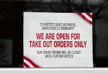 A sign in a restaurant window indicating it is open for take-out only due to the COVID-19 pandemic. (Stock photo)