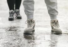 Two pedestrians walking on an icy surface. (Stock photo)