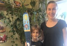 Carlotta James of Peterborough Pollinators with her 7-year-old son Salvador Haines, who painted this canoe paddle for the Painted Paddle art exhibit, which features 20 canoe paddles painted by volunteer artists on display at various locations in downtown Peterborough throughout February. Salvador says his paddle art, called The Elements, "represents the balance in nature with flowers blooming during the day and its roots growing by night, surrounded by the four elements: light blue for air, dark blue for water, red for fire and green for earth. Also, there’s a secret word painted in the roots, can you find it?". (Photo: Peterborough Pollinators / Facebook)