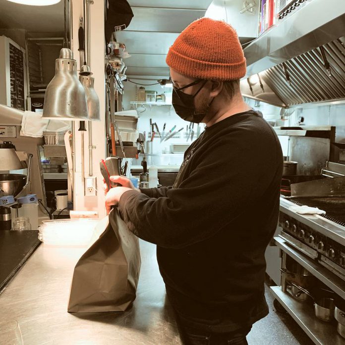 Rare owner and chef Tyler Scott packages an order for takeout. Currently Tyler and his sous chef Andrew Orde prep, cook, pack up, and cash out all orders themselves. (Photo courtesy of Rare)