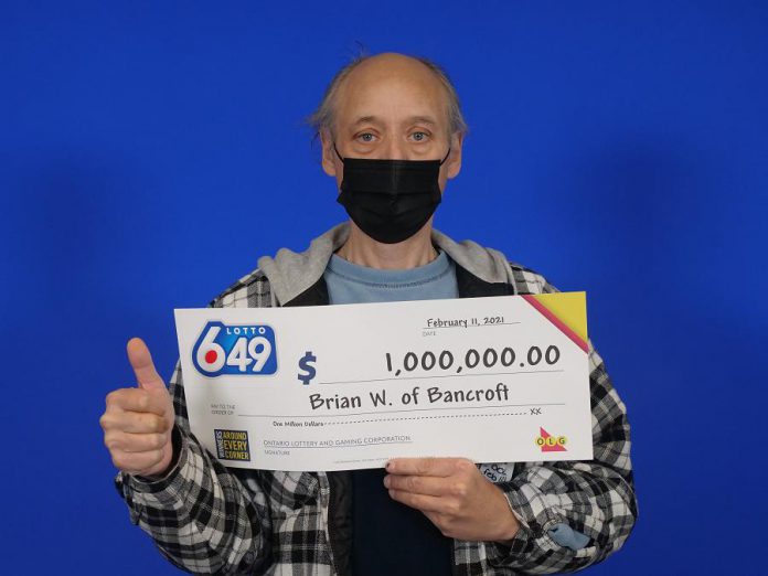 Brian Woodcox of Bancroft gives a thumbs up as he collects his $1 million cheque in Toronto. (Photo courtesy of OLG)