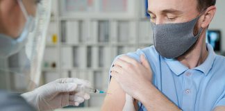 A middle-aged man receiving a vaccination. (Stock photo)
