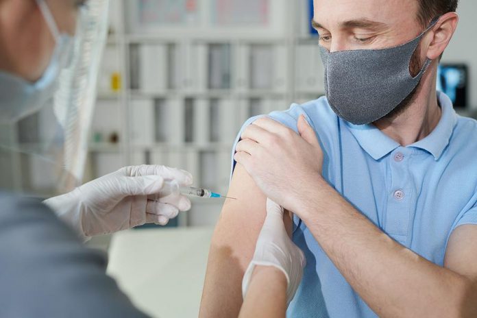 A middle-aged man receiving a vaccination. (Stock photo)