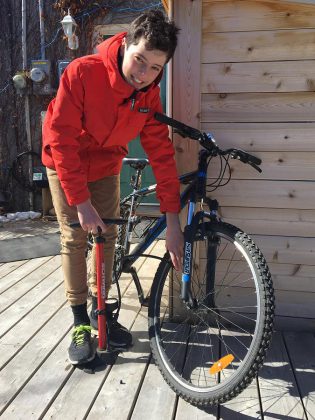 Aaron makes sure his tires are properly inflated; the correct pressure range for a tire is marked on the sidewall. You can get a bike pump with a built-in pressure gauge at local bike shops. (Photo: Jackie Donaldson)