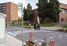 If cities were designed with the needs of women in mind, they would work better for everyone. For instance, women spend more time on public transit than men and spend more time on quick household-related errands and unpaid caregiving than men. During a GreenUP NeighbourPLAN infrastructure pop-up in Peterborough's Talwood neighbourhood, this temporary crosswalk was installed to demonstrate how a coloured crossing can improve pedestrian safety for women, men, and children. (Photo: Leif Einarson)