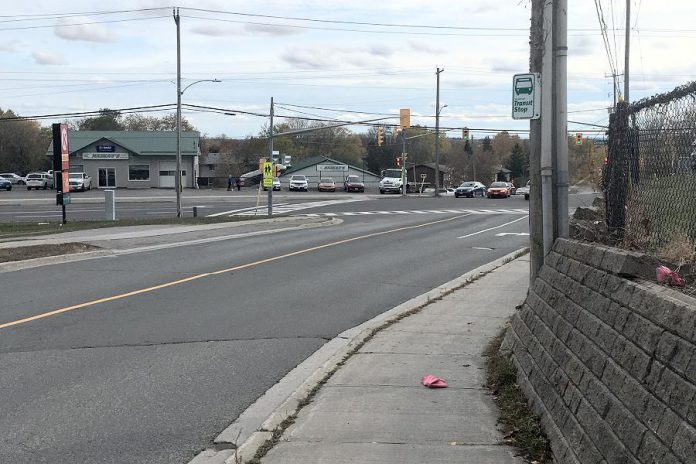 Because there is no safe crossing anywhere on Goodfellow between Clonsilla and Sherbrooke in Peterborough, families walking to St. Alphonsus Catholic Elementary School and Keith Wightman Public School have to walk along this narrow sidewalk, where people may also be standing at the transit stop. (Photo: GreenUP)