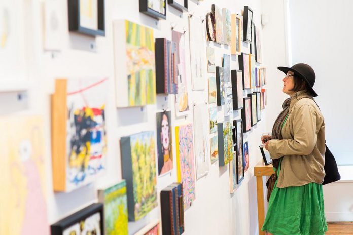 An arts supporter browses works by local artists at the annual Artspace 50/50 auction in 2019. Normally an in-person social event, the 2020 auction was cancelled because of the pandemic but is returning in virtual from April 26 to May 6, 2021 thanks to Melinda Richter, owner of Peterborough art appraisal and auction company Curated. (Photo: Matthew Hayes)