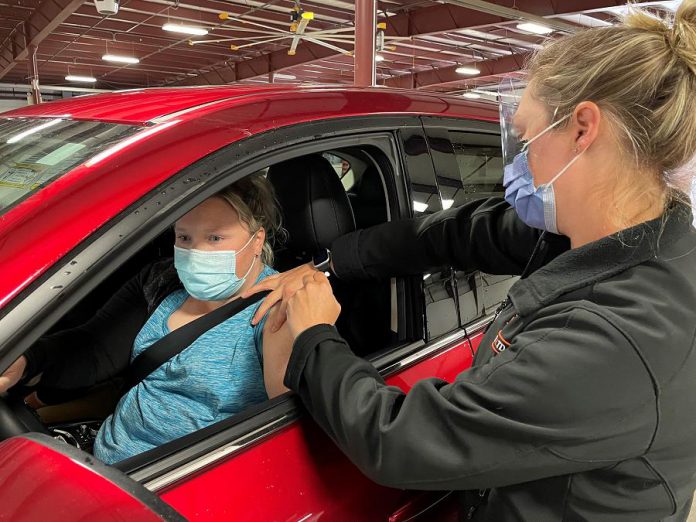 Katie Richardson of Bethany receives a dose of the Pfizer COVID-19 vaccine at the drive-through vaccination clinic at the Lindsay Exhibition on May 28, 2021, the 25,000th dose administered at the clinic since it opened in March. Lorah Otter, a registered practical nurse at Ross Memorial Hospital, administered the vaccine to Richardson and her fiancé. (Photo courtesy of Ross Memorial Hospital)