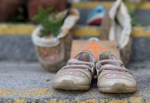 A pair of children's shoes on the steps of Peterborough City Hall, part of a community memorial created in response to last week's discovery of the remains of 215 Indigenous children buried at the former Kamloops Indian Residential School in British Columbia. (Photo: Bruce Head / kawarthaNOW)