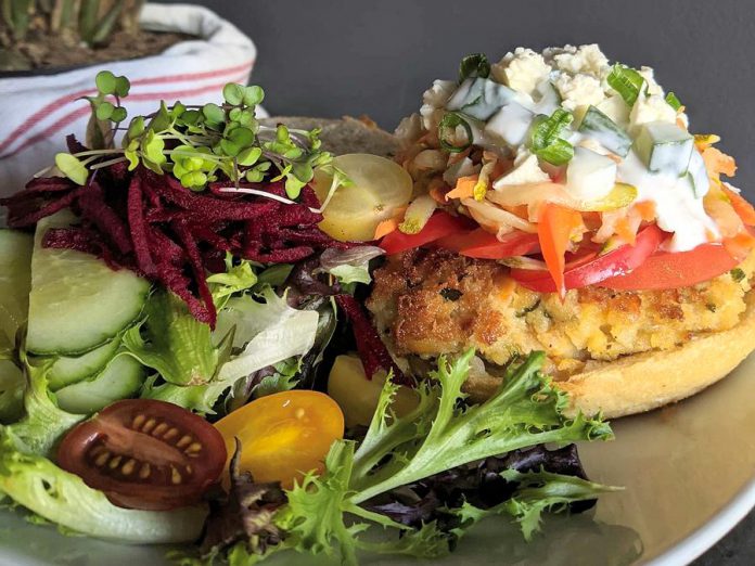 The menu at South - Eatery by Electric City Works features fresh takes on pub food classics, like this Green Apple and Curry Chickpea burger topped with cucumber mint raita, pickled vegetables, tomato, and feta. (Photo: Tara Lee Genge)