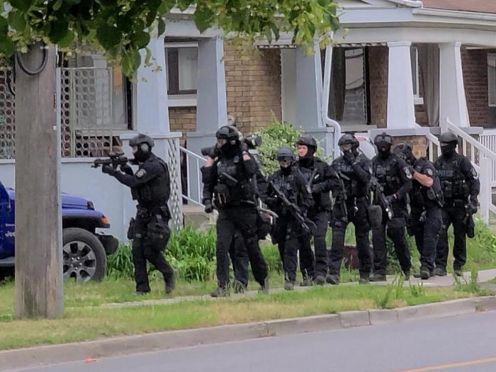 The Peterborough police's emergency response team approaching a home on Lock Street on June 24, 2021. Police were executing a search warrant, seized a quantity of crystal methamphetamine, and arrested and charged three people with various offences. (Screenshot from supplied video)