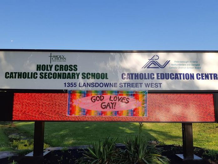A flag placed on the sign for Holy Cross Catholic Secondary School and the Catholic Education Centre at 1355 Lansdowne Street West in Peterborough. (Photo courtesy of Kimberly Liane)