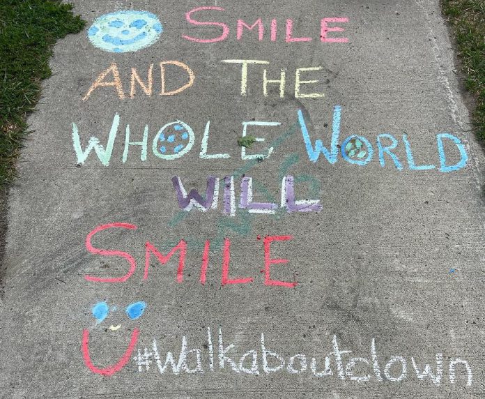 Every Tuesday morning, weather permitting, Carolyn Collins takes the Walk About Clown to senior homes in the area. She leaves uplifting chalk messages on her route and in front of the senior homes. (Photo courtesy of Carolyn Collins)