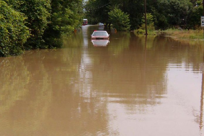 A car stands abandoned on a flooded road. (Photo: City of Peterborough Emergency & Risk Management Division)