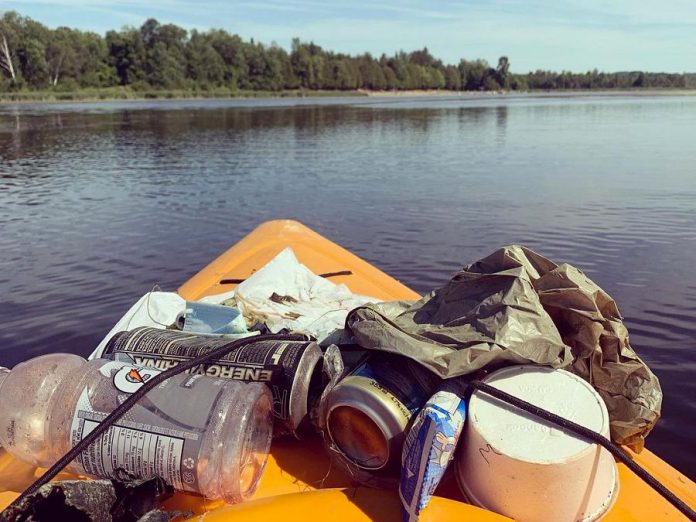 Christine Hoogkamer's kayak loaded with garbage she's collected from the water, as she paddles by the beach at Emily Provincial Park near Omemee. She has an Instagram account called 'Emily Garbage Shark' where she shares photos of the litter she's removed from the environment. (Photo courtesy of Christine Hoogkamer)