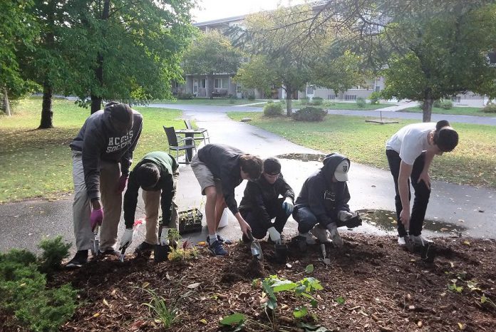 Before the pandemic, a group of students from Holy Cross Catholic Secondary School in Peterborough helped to plant trees, shrubs, and perennial flowers at Applewood Retirement Residence in the city's Kawartha Heights neighbourhood, as part of Peterborough GreenUP's Sustainable Urban Neighbourhoods program. This is an example of how the United Nations' Sustainable Development Goal of "quality education" can be implemented locally. (Photo: Hayley Goodchild)